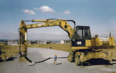 Ignoring the advice - image of a small child dwarfed by the earth moving equipment